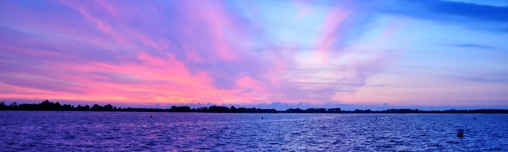 ピンク色に染まった雲と夕暮れの海岸