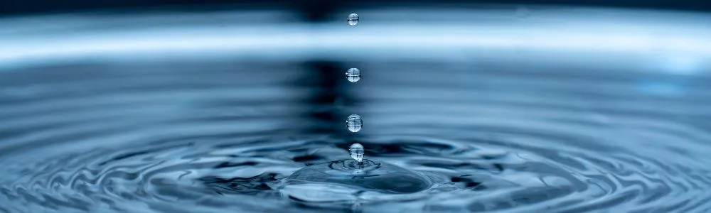 暗い水色の水面にできた波紋